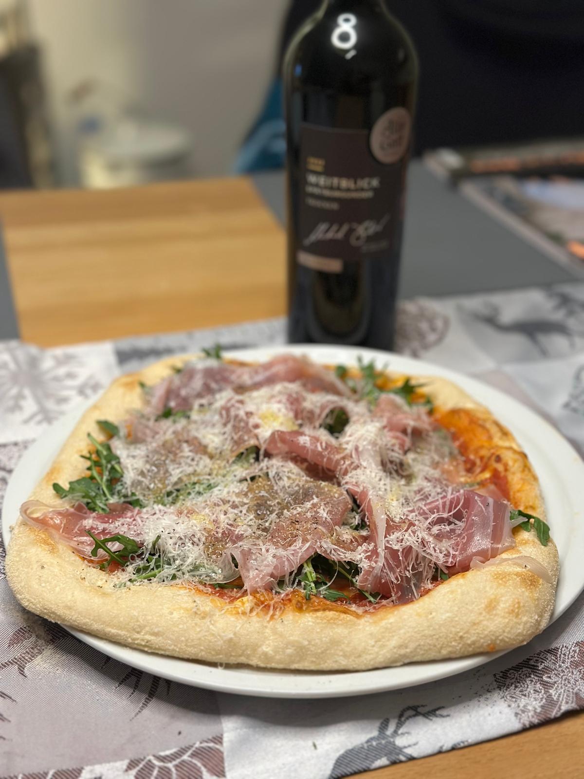 Knusprige Pizza mit Prosciutto crudo, Rucola und Parmesan